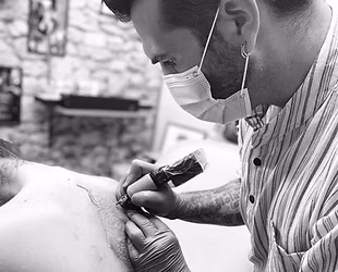 Yan le tatoueur réalisant un tatouage